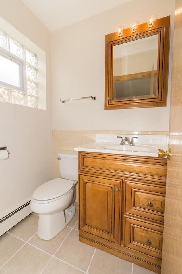 bathroom featuring toilet, tile walls, baseboard heating, vanity, and tile patterned flooring