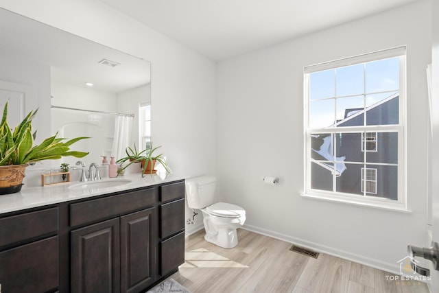 bathroom with toilet, hardwood / wood-style flooring, curtained shower, and vanity