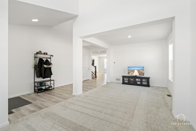 interior space featuring light colored carpet and a healthy amount of sunlight