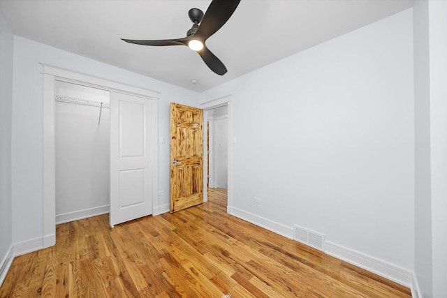 unfurnished bedroom with ceiling fan, light wood-type flooring, and a closet