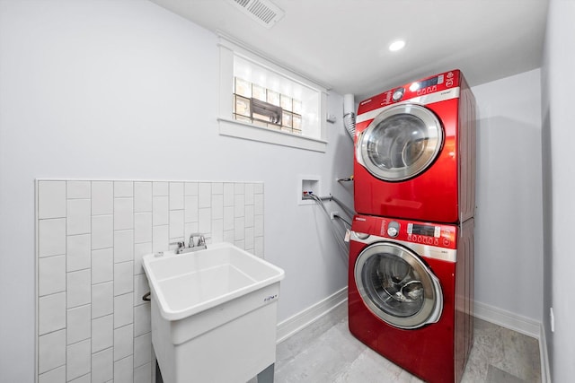 clothes washing area featuring stacked washer and clothes dryer and sink