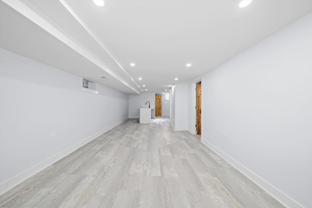 basement with light hardwood / wood-style flooring