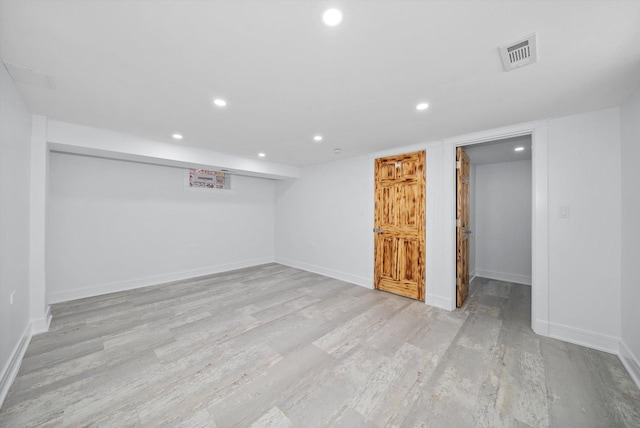 basement with light hardwood / wood-style flooring