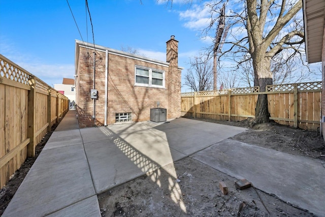 rear view of house featuring central AC unit and a patio area