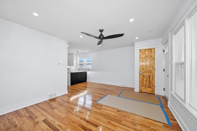 unfurnished living room with ceiling fan and light wood-type flooring