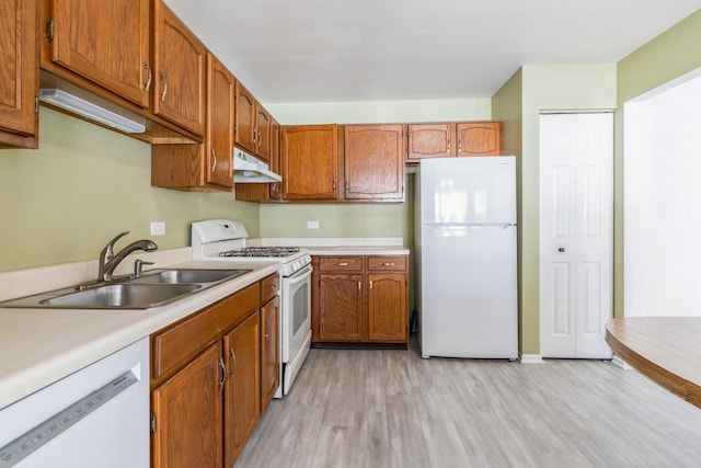 kitchen featuring sink, white appliances, and light hardwood / wood-style floors