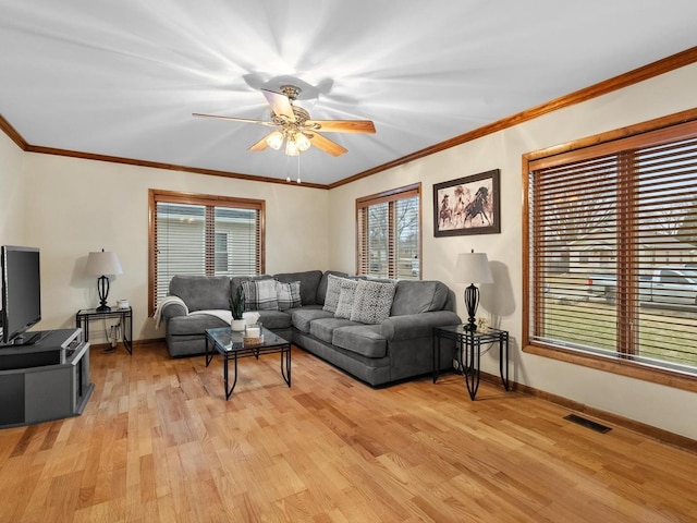 living room featuring ceiling fan, ornamental molding, and light wood-type flooring