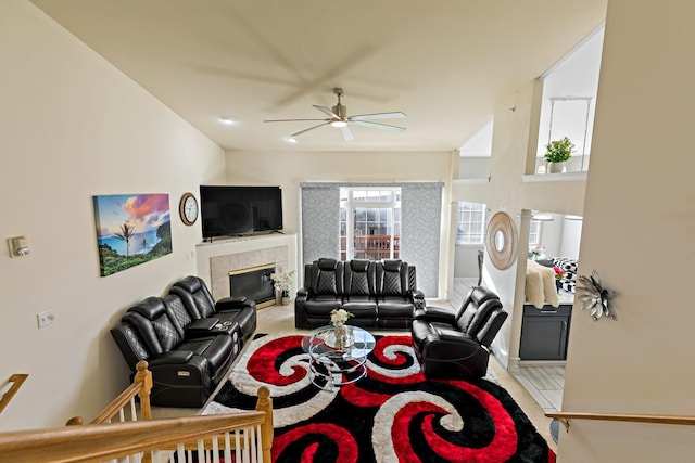 living room featuring a tile fireplace and ceiling fan