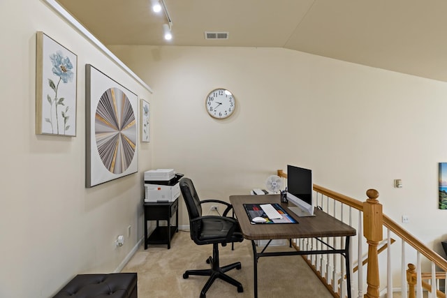 carpeted office with track lighting and lofted ceiling