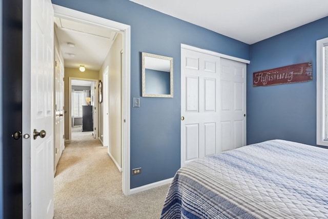 bedroom featuring light carpet, baseboards, and a closet