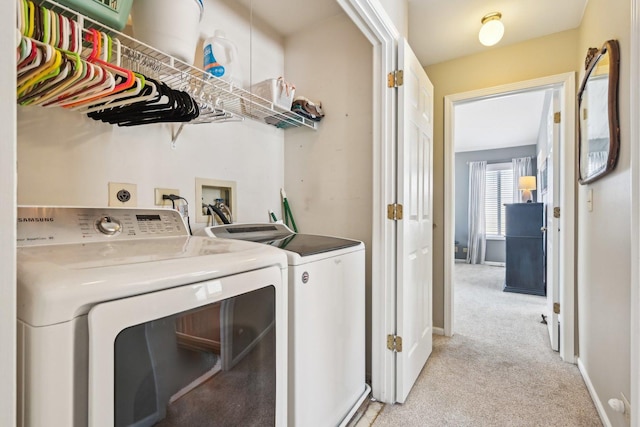 clothes washing area with light carpet, laundry area, baseboards, and washer and dryer