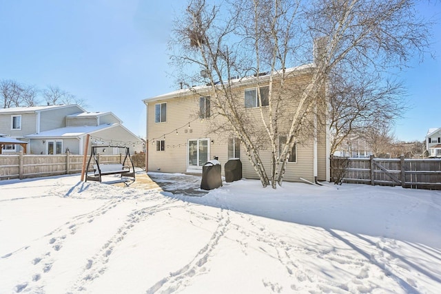 snow covered back of property with fence