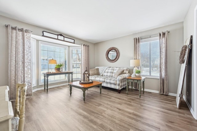 living room with a healthy amount of sunlight, baseboards, and wood finished floors