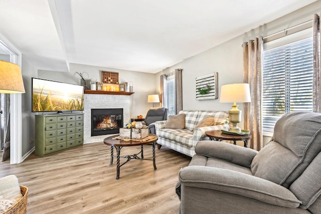 living room with light wood finished floors and a glass covered fireplace