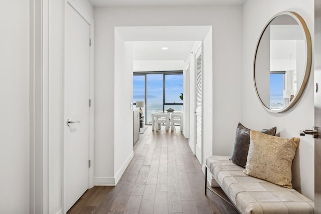 corridor with light wood-style flooring and baseboards