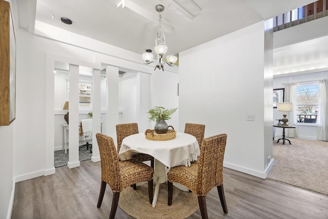 dining room with hardwood / wood-style floors and an inviting chandelier