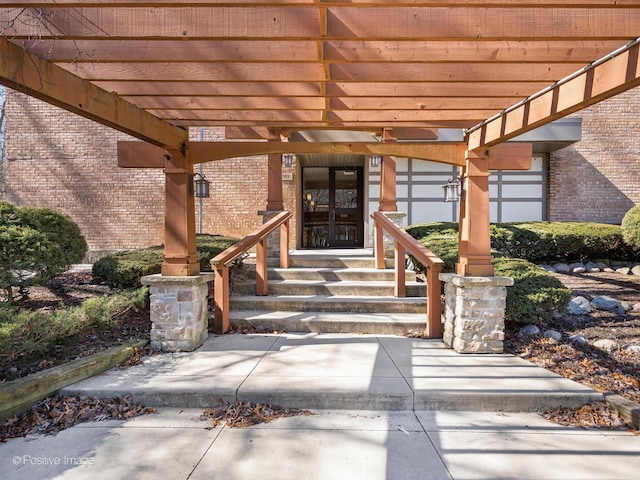 entrance to property with brick siding and a pergola