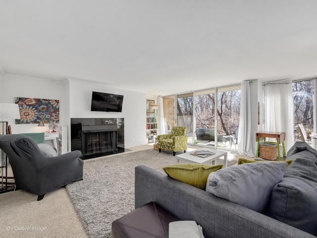 living room featuring plenty of natural light, a fireplace, and a wall of windows