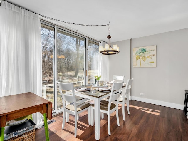 dining space featuring a chandelier, wood finished floors, visible vents, and baseboards