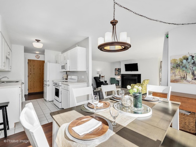 tiled dining area with a fireplace and a sink