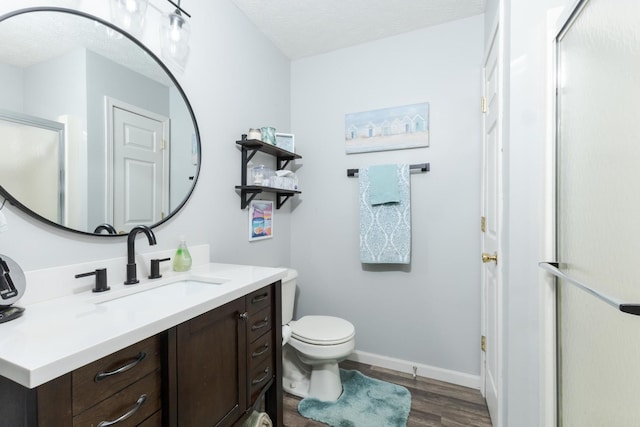 bathroom with vanity, hardwood / wood-style floors, a textured ceiling, and toilet