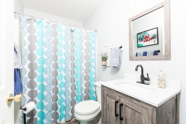 bathroom with vanity, a textured ceiling, and toilet