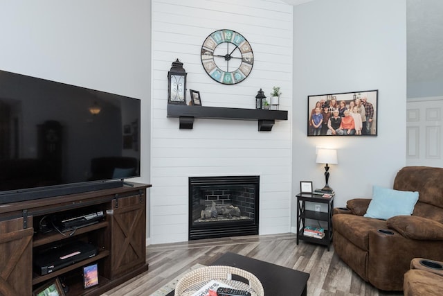 living room with a large fireplace and light wood-type flooring