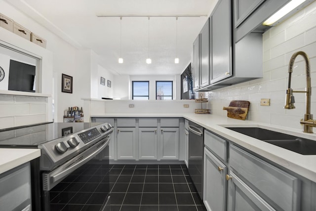 kitchen with stainless steel appliances, gray cabinets, sink, and decorative backsplash