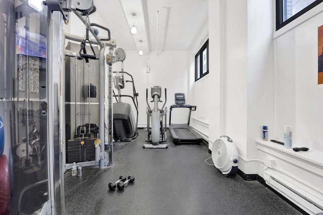 exercise room with a healthy amount of sunlight and a baseboard heating unit