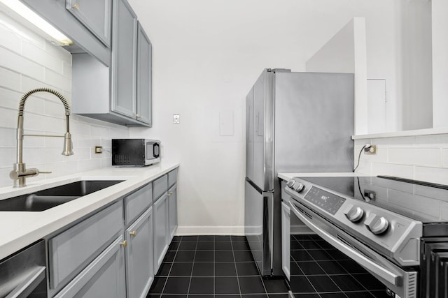 kitchen featuring electric stove, sink, gray cabinets, backsplash, and dark tile patterned flooring