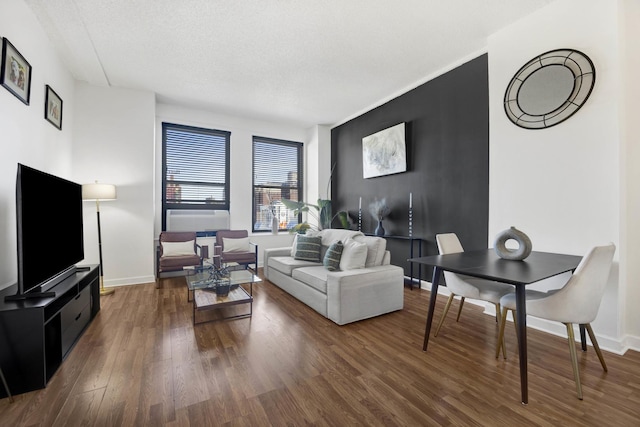 living room featuring dark wood-type flooring and a textured ceiling