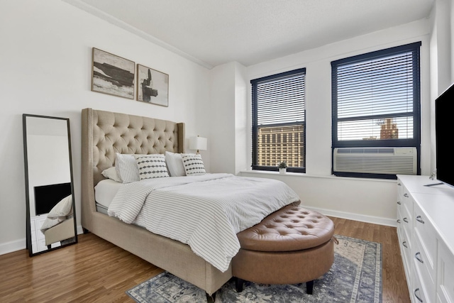 bedroom featuring multiple windows, cooling unit, and dark hardwood / wood-style flooring