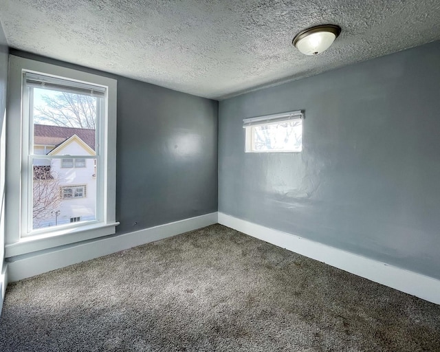 unfurnished room with carpet floors and a textured ceiling