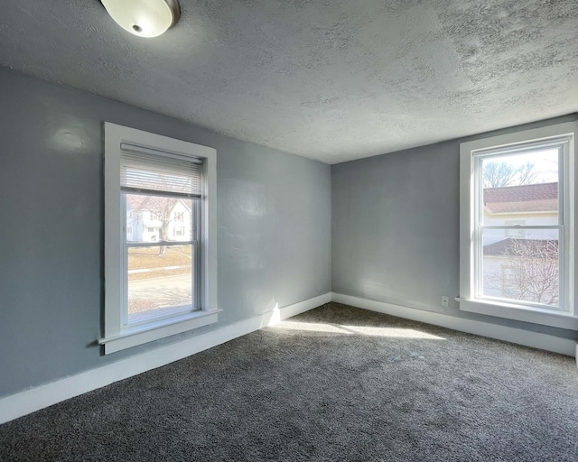 carpeted empty room with a textured ceiling