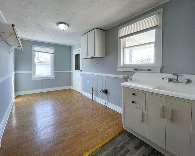 kitchen featuring sink, a textured ceiling, dark wood-type flooring, and white cabinets