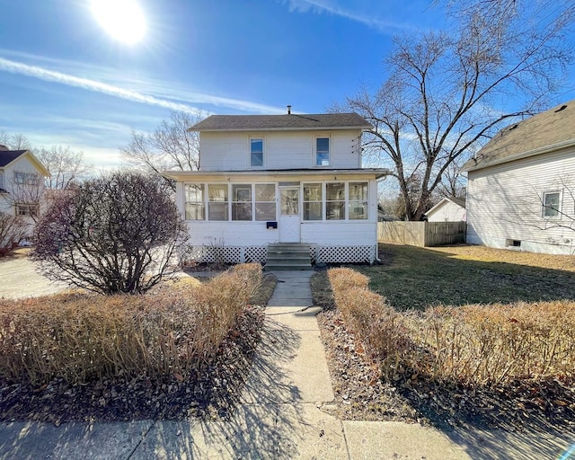 view of front of property featuring a sunroom and a front yard