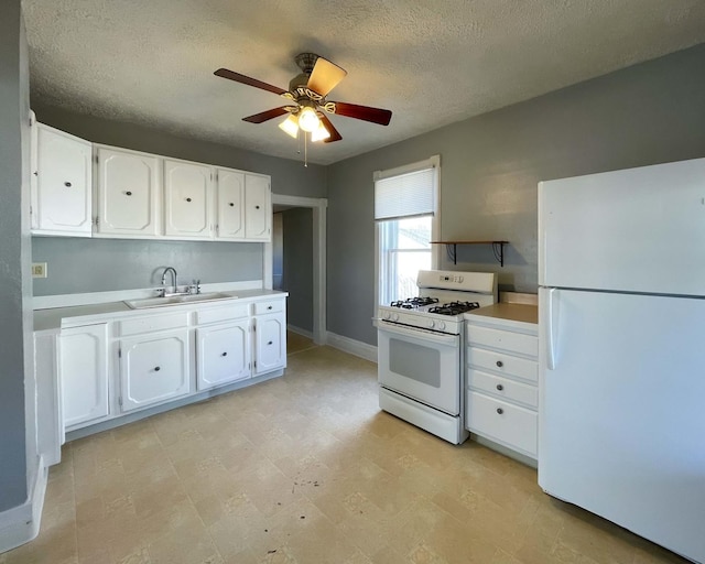 kitchen featuring sink, white cabinets, white appliances, ceiling fan, and a textured ceiling