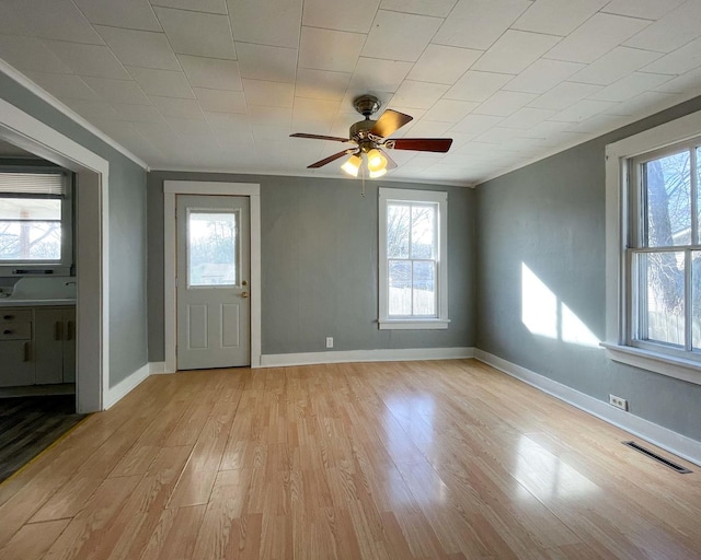 foyer entrance with crown molding, ceiling fan, and light wood-type flooring