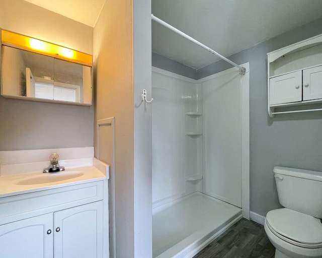 bathroom with a shower, wood-type flooring, vanity, and toilet