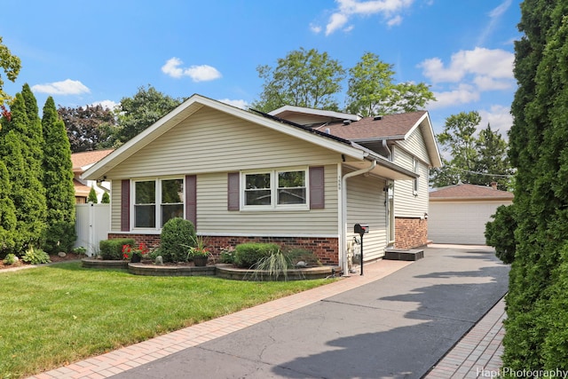 view of front of property with a garage, an outdoor structure, and a front yard