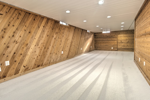 unfurnished room featuring light carpet and wood walls