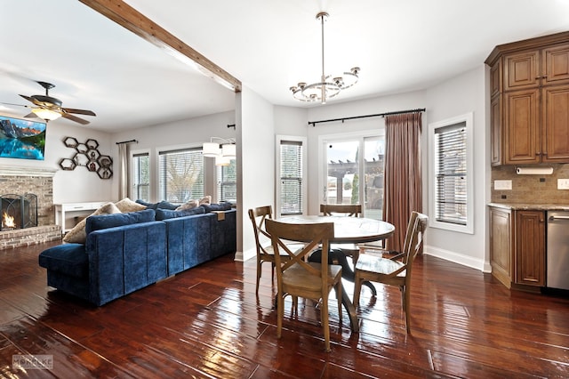 dining space with dark wood-style floors, a brick fireplace, and baseboards