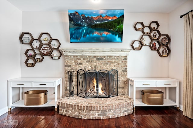 unfurnished living room featuring a fireplace, baseboards, and wood finished floors