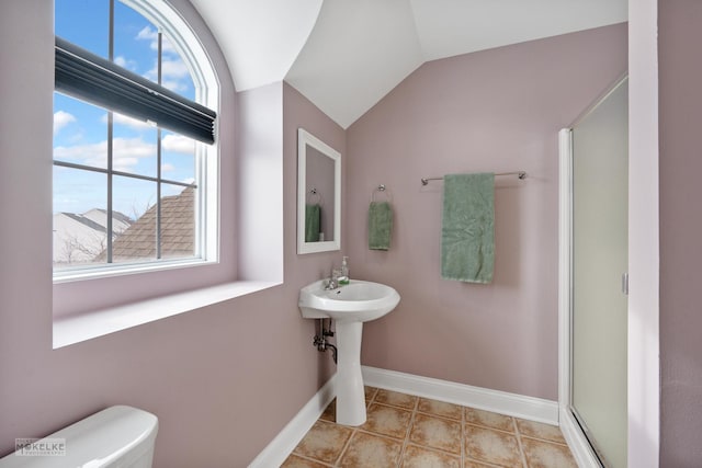 bathroom featuring baseboards, lofted ceiling, toilet, tile patterned flooring, and a shower stall