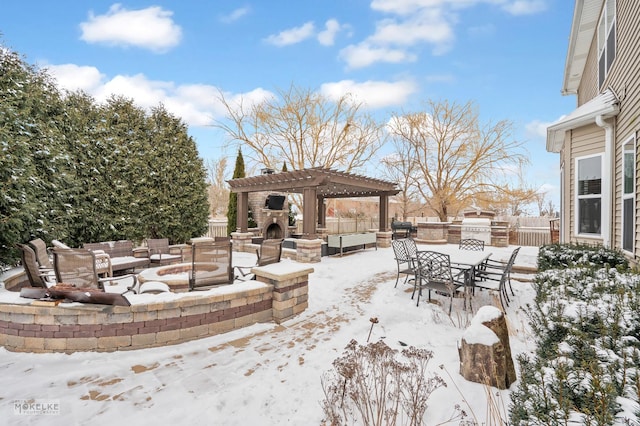 snow covered patio featuring an outdoor living space with a fireplace, fence, a pergola, and area for grilling