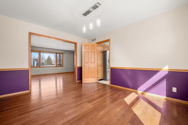 empty room with baseboards and wood finished floors