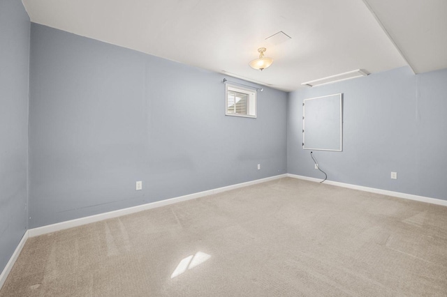 carpeted empty room featuring baseboards