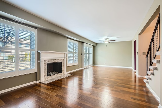 unfurnished living room with ceiling fan, a fireplace, and dark hardwood / wood-style flooring