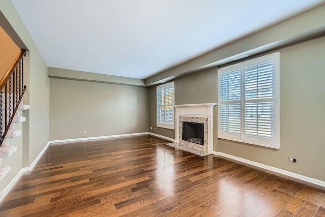 unfurnished living room with a premium fireplace and dark hardwood / wood-style floors