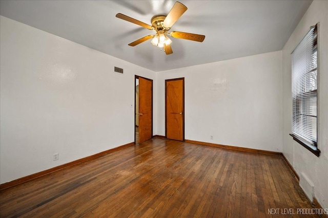 spare room with dark wood-type flooring and ceiling fan